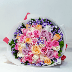 Sweet assorted rose bouquet with mix color roses and blue gypso in tissue wrap