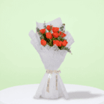 Orange roses and green eucalyptus branches wrapped in textured white non-woven paper, tied with satin ribbon.