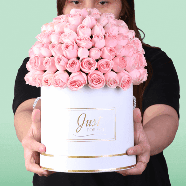 White round box filled with neatly arranged pink roses with a Mother’s Day topper placed on top, premium floral gift arrangement for Mom