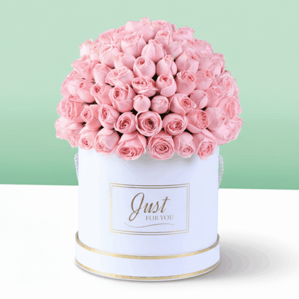 White round box filled with neatly arranged pink roses with a Mother’s Day topper placed on top, premium floral gift arrangement for Mom